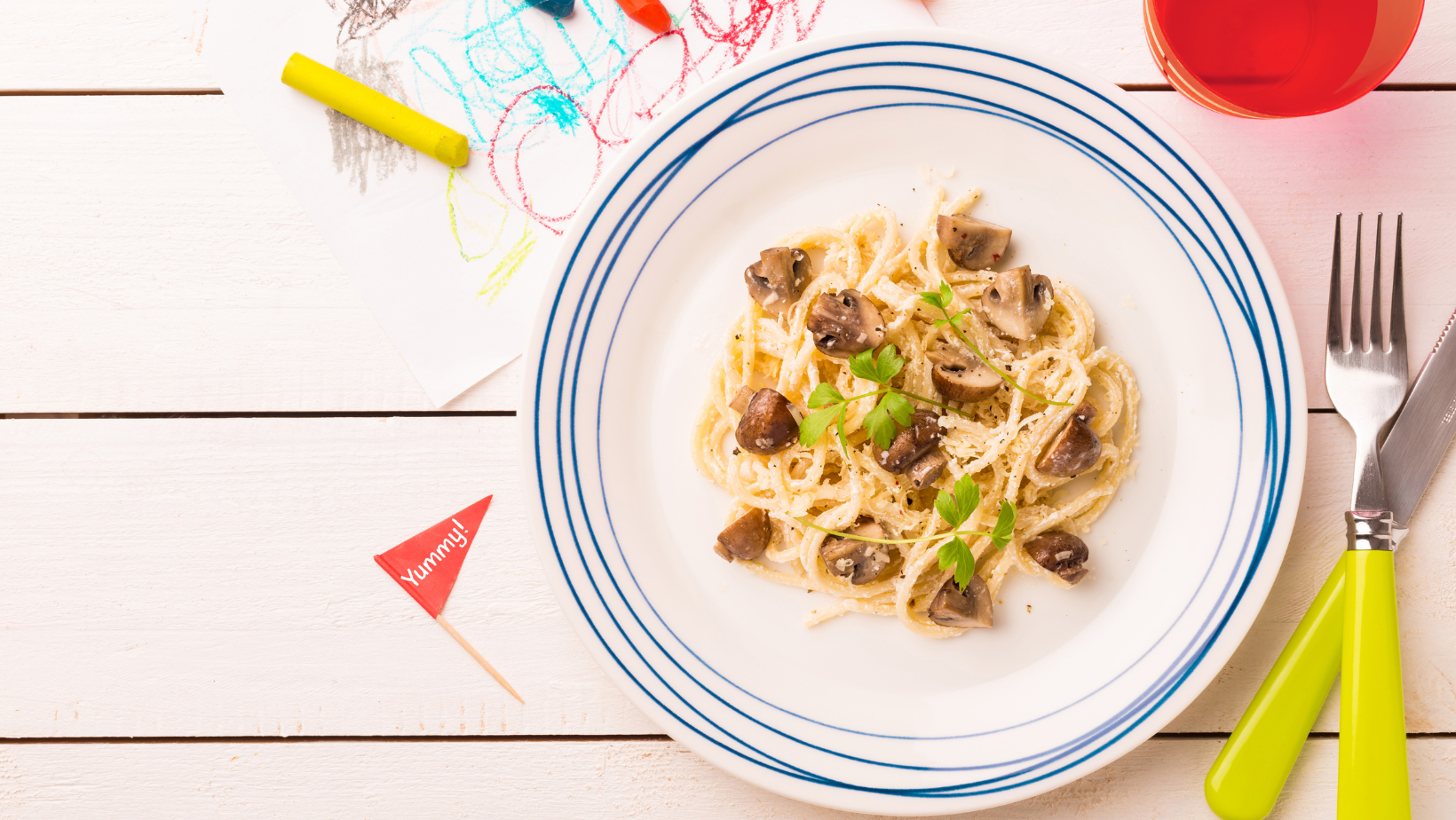 Kids plate of spaghetti and meatballs served with a small drink